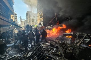 First responders stand amid rubble at the site of an Israeli airstrike in Beirut's Corniche al-Mazraa neighbourhood on Wednesday